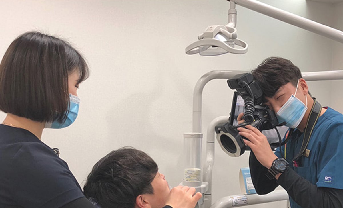 뉴욕연합치과의원 진료실 — 구강 카메라로 입안 상태를 확인하는 장면